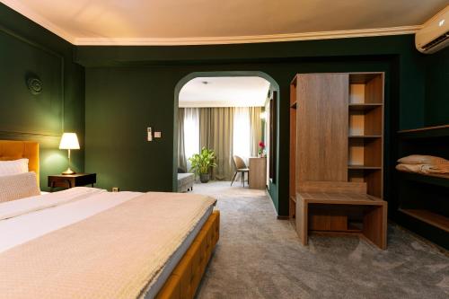 a bedroom with a large bed and green walls at Hotel Cocó in Timişoara