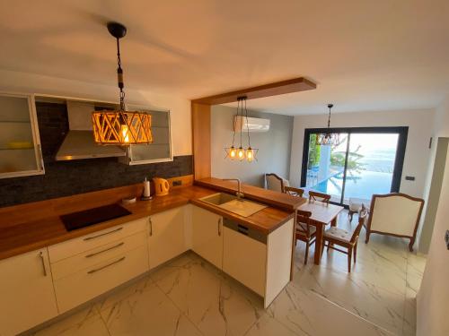 a kitchen with a table and a dining room at Villa Aleph-Kiralık Müstakil havuzlu lüx villa in Bodrum City