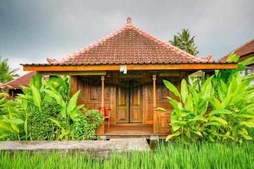 a wooden house in the middle of a garden at Ubud Sawah Scenery Villa and Homestay in Tegalalang