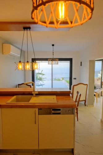 a kitchen with a counter with a sink and a window at Villa Aleph-Kiralık Müstakil havuzlu lüx villa in Bodrum City