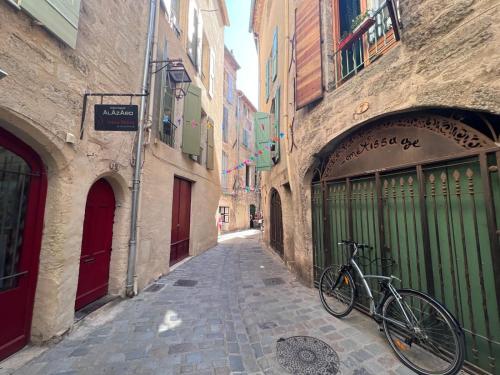 a bike parked in an alley between two buildings at Pézenas Centre Historique - plages à 20 mn in Pézenas