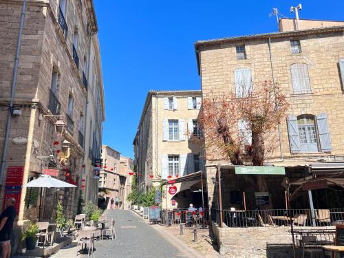 an empty street in a city with buildings and tables at Pézenas Centre Historique - plages à 20 mn in Pézenas