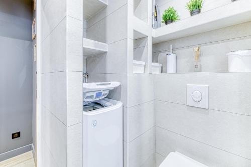a white laundry room with a washer and dryer at Homency - Résidence Ménandière F5 in L'Alpe-d'Huez
