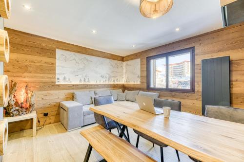 Cette chambre dispose d'une table en bois avec un ordinateur portable. dans l'établissement Homency - Résidence Ménandière F5, à L'Alpe-d'Huez