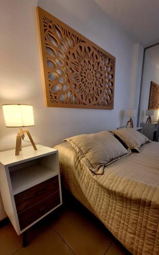 a bedroom with a bed and a table with a lamp at Departamento Cofico in Córdoba