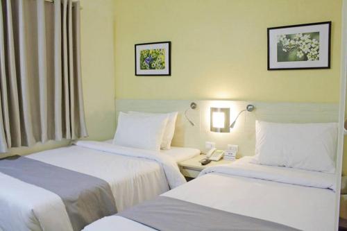 a hotel room with two beds and a phone at Hamersons Hotel Cebu in Cebu City
