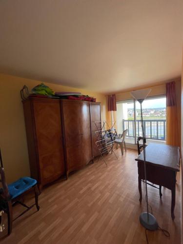 un salon avec une table et une grande fenêtre dans l'établissement Appartement vu sur mer, à Cabourg