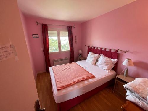 - une chambre rose avec un lit et une fenêtre dans l'établissement Appartement vu sur mer, à Cabourg
