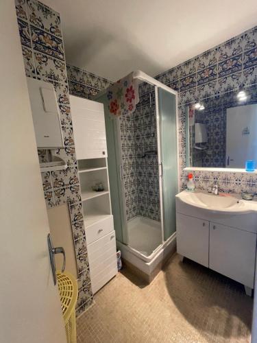 une salle de bain avec douche et lavabo dans l'établissement Appartement vu sur mer, à Cabourg