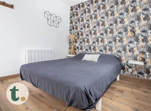 - une chambre avec un lit et un mur orné d'une fresque murale dans l'établissement Tranquiloue - Chez nous - 8min du PuyduFou, à La Verrie