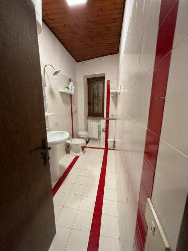 a bathroom with a red stripe on the floor at Locanda delle sorelle nel centro storico in Campagnano di Roma