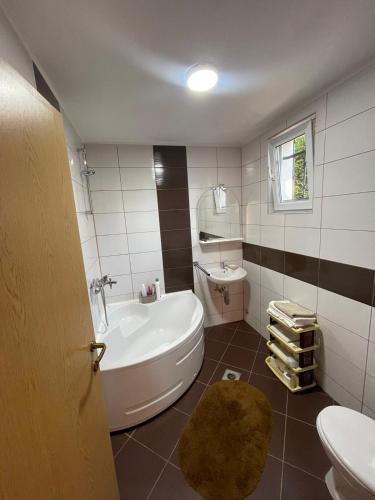 a bathroom with a tub and a toilet and a sink at Zeleni kutak in Sarajevo
