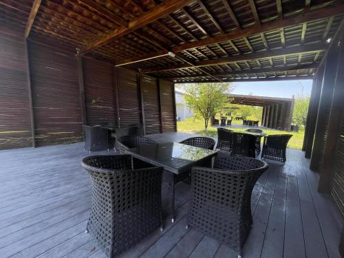 a patio with tables and chairs on a wooden deck at Arena Apartments & Villas Guba in Quba