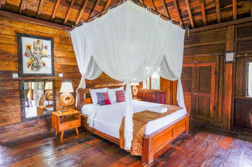 a bedroom with a bed with a canopy at Ubud Sawah Scenery Villa and Homestay in Tegalalang