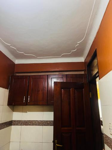 una stanza con armadi in legno e un soffitto di Magical suite a Kampala
