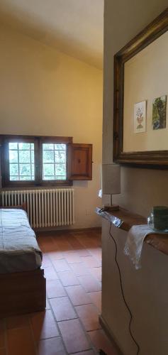 a bedroom with a bed and a mirror on the wall at Stirpe nel Bosco - Fiocco in Montevettolini