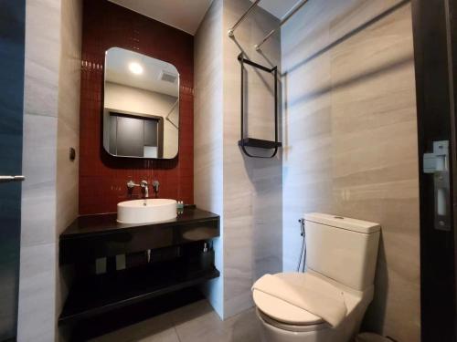 a bathroom with a toilet and a sink and a mirror at 24a网红无边泳池EDGE豪华单卧室套房 海滩3分钟 in Pattaya Central