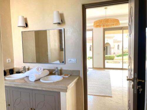 a bathroom with two sinks and a large mirror at Luxury Villa Rêve D'ahlam à MARRAKECH in Oulad Boudene