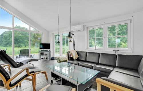 ein Wohnzimmer mit einer Couch und einem Glastisch in der Unterkunft Holiday Home Jtagholmsvej Rømø Denmark in Rømø Kirkeby