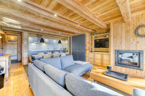 un salon avec un canapé et une télévision dans l'établissement Homency - Chalet Elussa, à L'Alpe-d'Huez