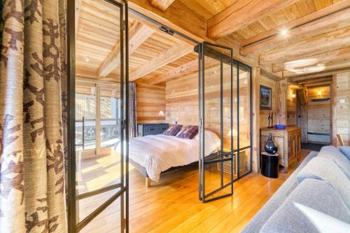 a bedroom with a bed in a room with wooden walls at Homency - Chalet Elussa in L'Alpe-d'Huez