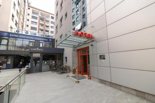 a building with a red door in a city at Hotel Vidović in Banja Luka