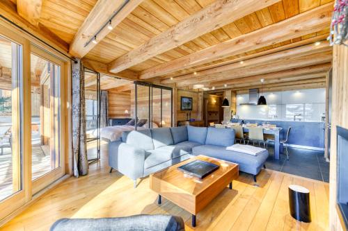 a living room with a couch and a table at Homency - Chalet Elussa in L'Alpe-d'Huez