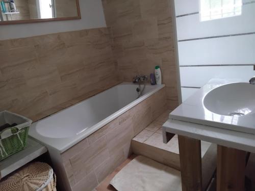 une salle de bain avec une baignoire et un lavabo dans l'établissement Maison de vacances, à Anglars-Nozac