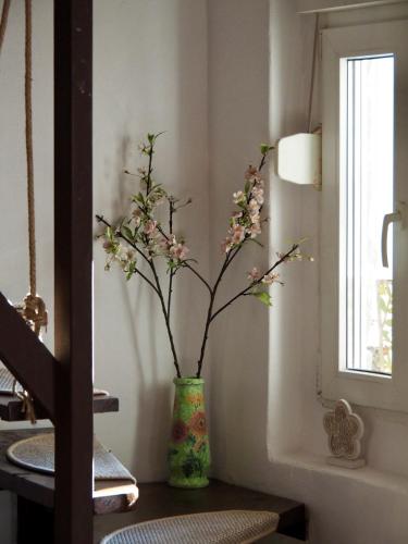 a vase with flowers sitting on a table next to a window at Holiday House Valiug in Văliug