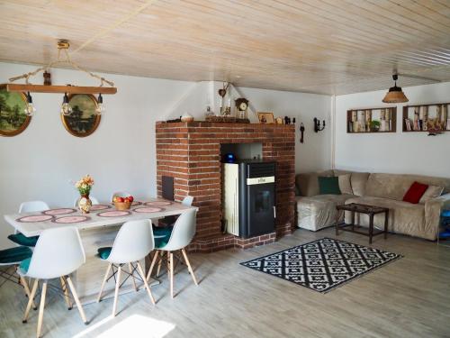 a living room with a fireplace and a table and chairs at Holiday House Valiug in Văliug