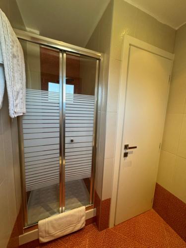 a shower with a glass door in a bathroom at Possidi Hiliadou Boutique Resort in Possidi