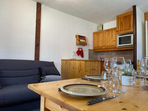 - une table en bois avec des verres à vin dans l'établissement Studio cosy au cœur de Samoëns, proche commerces et ski bus, balcon, parking, animaux acceptés - FR-1-624-157, à Samoëns