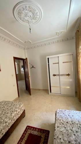 an empty room with two beds and a door at Welcome to Big BL's house, Close to Tanger Med in Ksar es Sghir