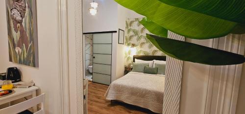 Dormitorio pequeño con cama con almohadas verdes en Room Lui, en Rijeka
