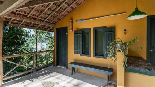 a porch with a bench on the side of a house at Angra House - Linda Casa em ILHA in Angra dos Reis
