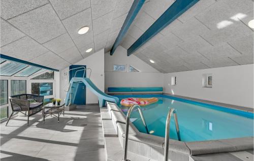 a swimming pool with a slide in a room with a swimming pool at Cozy Home In Hadsund With Sauna in Helberskov