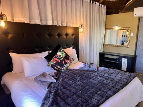 a bedroom with a large bed and a mirror at Lapa Lange Game Lodge in Mariental