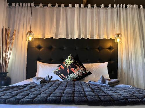a bedroom with a large bed with white curtains at Lapa Lange Game Lodge in Mariental
