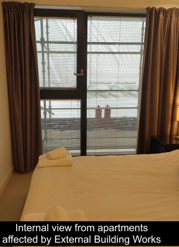 a bedroom with a bed and a large window at Cleyro Serviced Apartments - Finzels Reach in Bristol