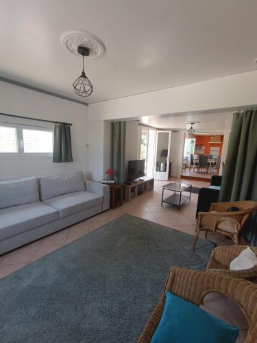 un salon avec un canapé blanc et un salon avec un canapé dans l'établissement La Villa des Fleurs, à Saint-Simon-de-Bordes