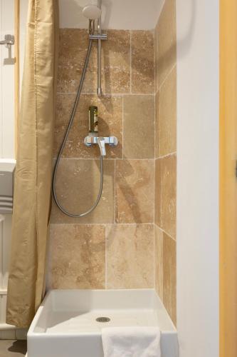 a bathroom with a shower with a sink at Logis Hôtel Restaurant Le Louvre in Sault-de-Vaucluse