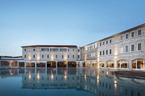 a building with a pool of water in front of it at Private 2 bedrooms home in Saturnia centre in Saturnia