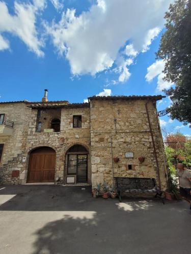 a stone building with a door and a garage at Private 2 bedrooms home in Saturnia centre in Saturnia