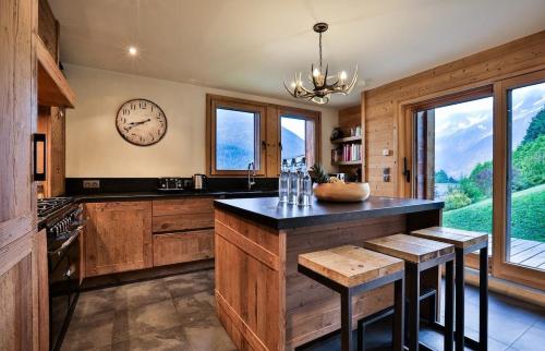 une cuisine avec une grande horloge murale dans l'établissement Chalet Arte 12px Hot Bath Sauna, aux Houches