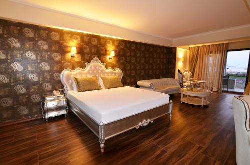 a bedroom with a king sized bed and a living room at Azka Hotel in Bodrum City