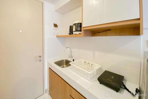 eine weiße Küche mit einem Waschbecken und einem WC in der Unterkunft Warm and Simply Look Studio Apartment at Tokyo Riverside PIK 2 By Travelio in Rawalembang