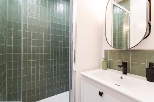 une salle de bain avec un lavabo et un miroir dans l'établissement L'élégant - Appartement Fonctionnel Plein-centre de Douai, à Douai