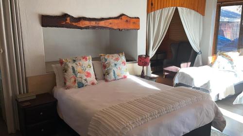 a bedroom with a large bed with pillows on it at Oppi Draai Guesthouse in Oudtshoorn