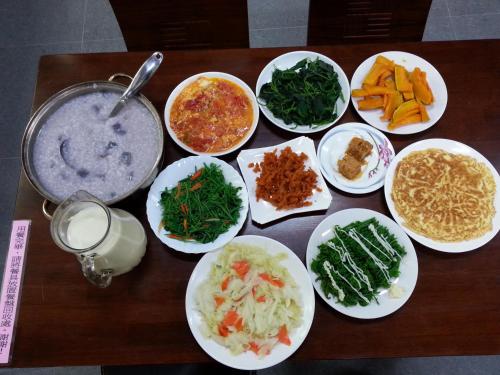 una mesa con platos de comida en una mesa en Xinyue B&B, en Fenglin