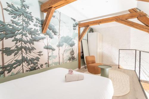 - une chambre avec un lit blanc et une fresque murale dans l'établissement L'élégant - Appartement Fonctionnel Plein-centre de Douai, à Douai